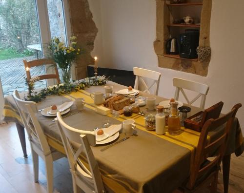 a dining room table with a yellow table cloth at Domaine de la Castagnère in Castetnau-Camblong