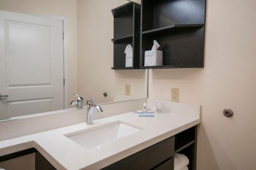 y baño con lavabo y espejo. en Candlewood Suites - Baton Rouge - College Drive, an IHG Hotel en Baton Rouge
