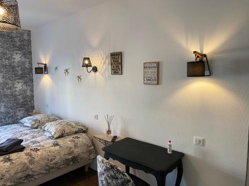 a bedroom with a bed and a desk and a table at logis Paul Massy in Meschers-sur-Gironde