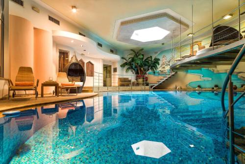 a large swimming pool in a hotel room at Leading Relax Hotel Maria in Moena