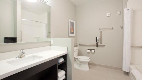 a white bathroom with a sink and a toilet at Candlewood Suites Grand Island by IHG in Grand Island