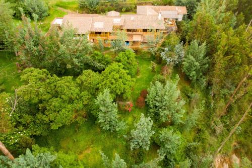 an aerial view of a house in the midst of trees at Hacienda Jimenita Wildlife Reserve in Puembo