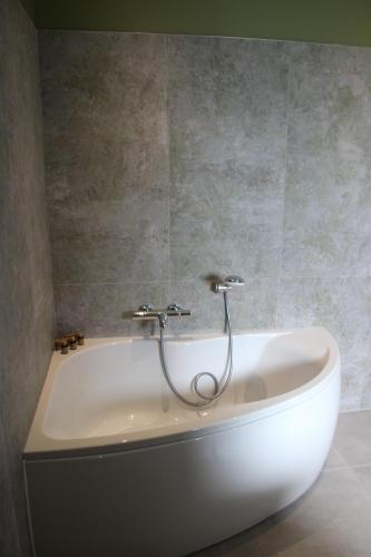 La salle de bains est pourvue d'une baignoire avec un flexible. dans l'établissement La campagne Pramaïsse, à Mane