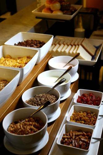 a table topped with bowls of different types of food at De Chai Oriental Nimman - SHA Plus in Chiang Mai
