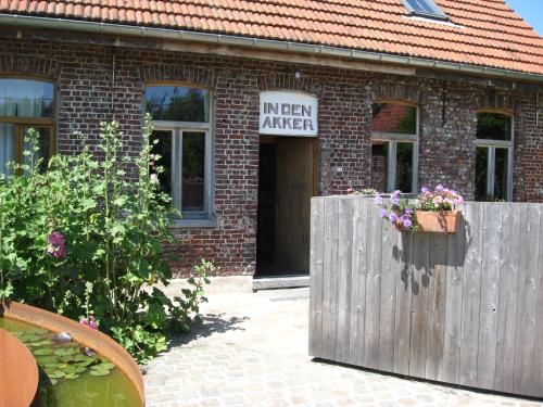 un edificio de ladrillo con una señal que lee ira interior en in Den Akker, en Oudenaarde