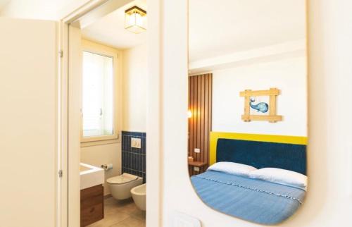 - une salle de bains avec un miroir et un lit dans une chambre dans l'établissement Mare e marmellata, à Ravenne