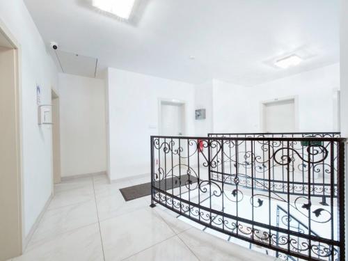 a staircase in a white room with a wrought iron railing at Pension Amanda in Berlin