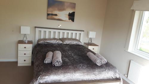 a bedroom with a bed with pillows and two night stands at Beautiful 50 Riverun in Belturbet