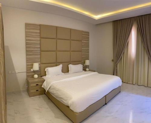 a bedroom with a large white bed and a window at روز الخيال للشقق المخدومة 2 in Al Kharj