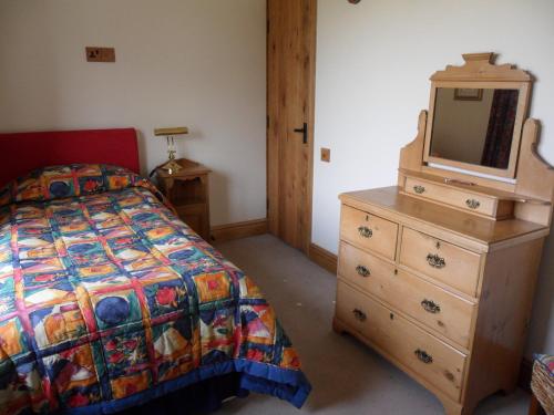 a bedroom with a bed and a dresser with a tv on it at 2 Bed Barn near Newport Shropshire in Newport