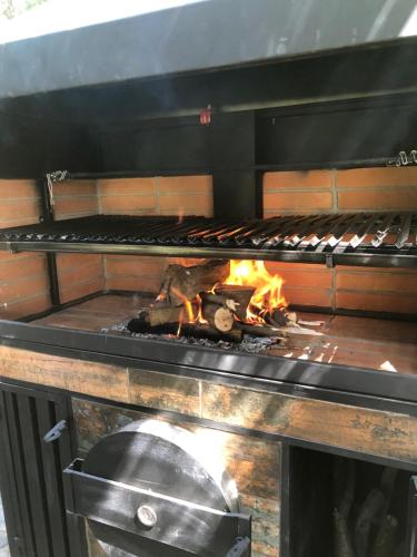 a grill with a fire inside of it at Casa de Montaña inmersa en Bosque Nativo in San José de Maipo