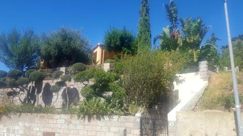 a stone wall with trees on top of it at Terrazze al Mare (Urlaub an Sardiniens Westküste) in Torre Dei Corsari