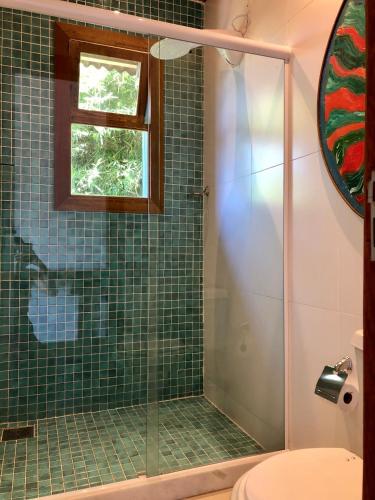 a bathroom with a shower with green tile at Pousada Pataca de prata - Pousada de Época in Petrópolis