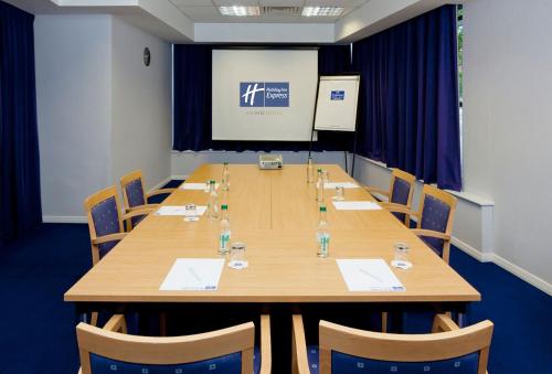 a conference room with a large wooden table and chairs at Holiday Inn Express Portsmouth Gunwharf Quays by IHG in Portsmouth