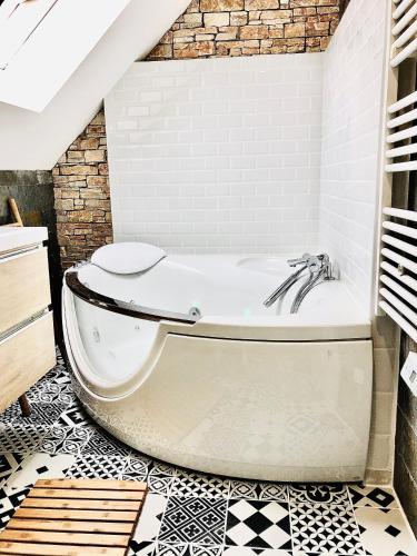 La salle de bains est pourvue d'une baignoire et d'un mur en briques. dans l'établissement Haut Standing proche gare, à Rouen