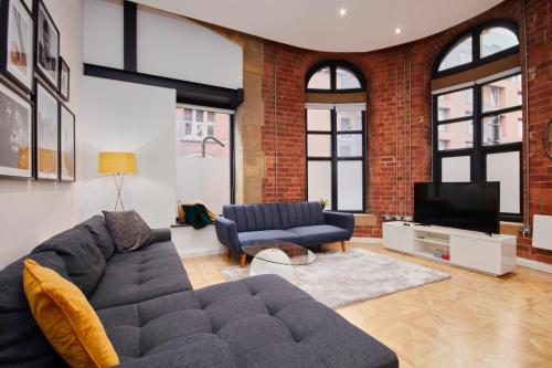 a living room with a couch and a tv at 2Bed NYC Style Apartment in Central Leeds in Leeds