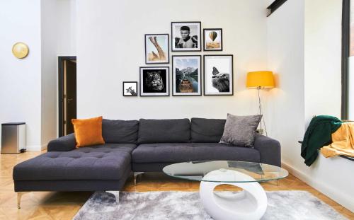 a living room with a blue couch and a glass table at 2Bed NYC Style Apartment in Central Leeds in Leeds