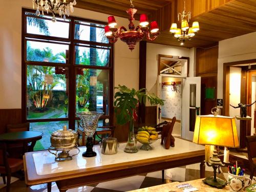 a kitchen with a table with bananas and a window at Pousada Pataca de prata - Pousada de Época in Petrópolis