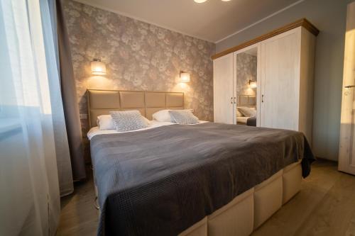 Otepää Holiday Apartment في أوتيبا: غرفة نوم بسرير كبير مع وسادتين