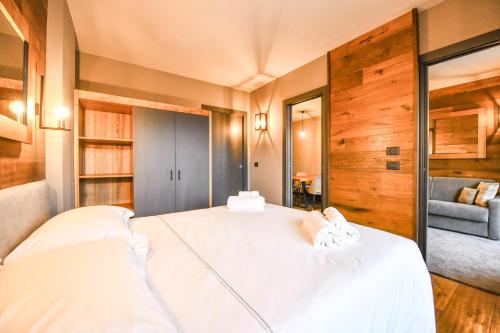 a bedroom with a white bed and a blue couch at Chalet Everest - Luxury Apartments in Prato Nevoso