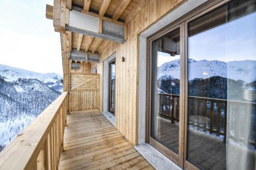 a room with a balcony with a view of mountains at Chalet Everest - Luxury Apartments in Prato Nevoso