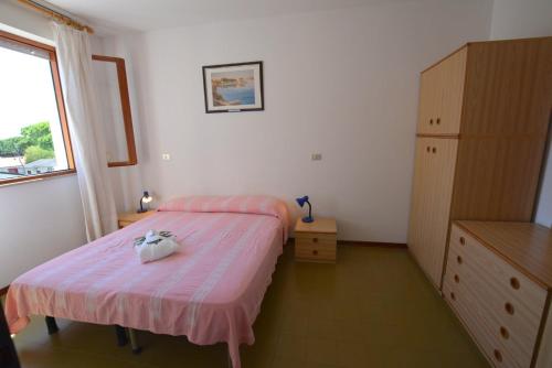 リニャーノ・サッビアドーロにあるLignano Riviera with poolのベッドルーム1室(ベッド1台、ドレッサー、窓付)