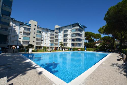 リニャーノ・サッビアドーロにあるLignano Riviera with poolのアパートメントの建物の前にスイミングプールがあります。