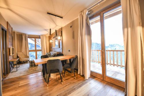 a dining room with a table and chairs and a balcony at Chalet Everest - Luxury Apartments in Prato Nevoso