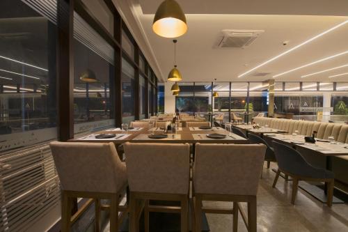 a long dining room with a long table and chairs at AARYA MANSION V One Hotel in Hassan