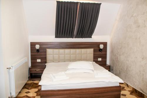 
Un pat sau paturi într-o cameră la Hotel Corina

