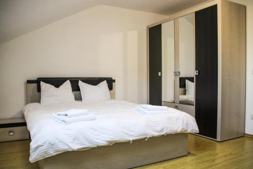 ein Schlafzimmer mit einem großen Bett mit Handtüchern darauf in der Unterkunft Hotel Corina in Borsa