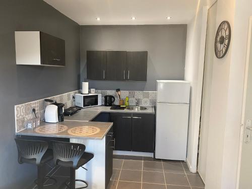une cuisine avec un réfrigérateur blanc et un évier dans l'établissement Studio, à Brignoles