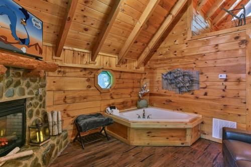 baño con bañera y chimenea en una cabaña en Alone at Last - Sage Vacations, en Pigeon Forge