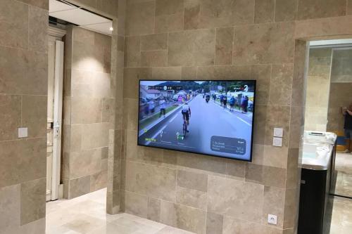 a flat screen tv hanging on a wall at NID D AMOUR F1 40m2 calme RDC possibilité jacuzzi hammam in Chamalières