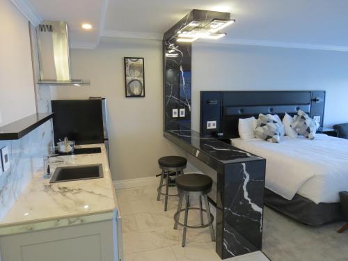 a bedroom with a bed and a kitchen with a sink at Dockside Suites in Digby