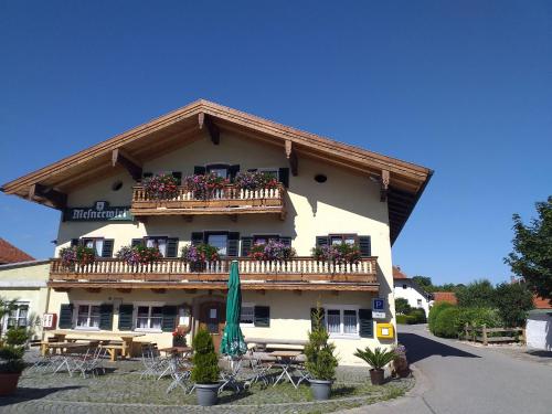 um edifício com uma varanda com mesas e cadeiras em Mesnerwirt em Neukirchen am Teisenberg