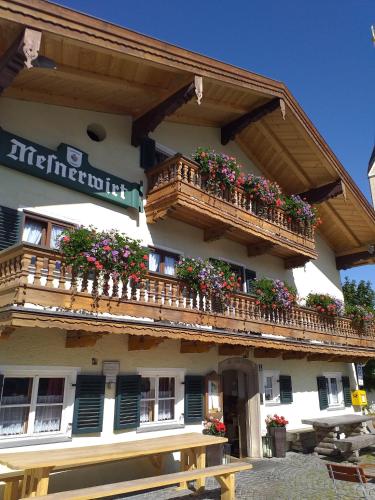ein Gebäude mit Balkonen und Blumenkästen darauf in der Unterkunft Mesnerwirt in Neukirchen am Teisenberg