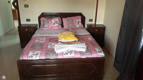 a bed with a pink blanket with a hamburger on it at Moonlight Home in Luxor