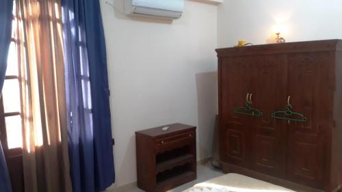 a bedroom with a wooden cabinet and a window at Moonlight Home in Luxor
