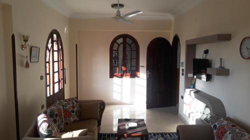a living room with a couch and two arched windows at Moonlight Home in Luxor