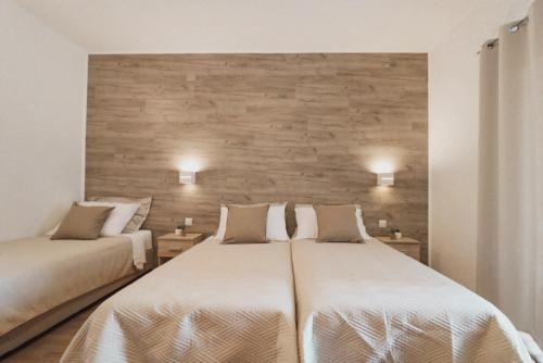 a bedroom with two beds and a brick wall at Hotel Orion in Vodice