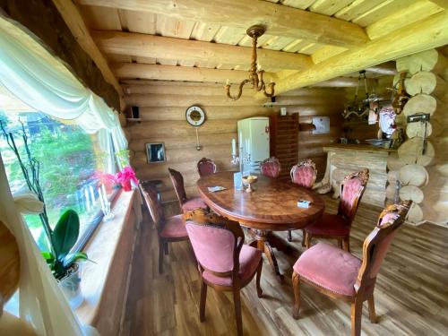 ein Esszimmer mit einem Holztisch und Stühlen in der Unterkunft The Mountain's Sea Chalet in Colibiţa