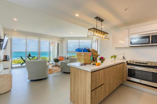 a kitchen and living room with a view of the ocean at Azure Beach Residences in Palm-Eagle Beach