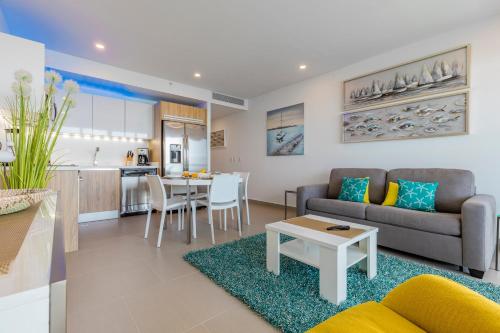 a living room with a couch and a table at Azure Beach Residences in Palm-Eagle Beach