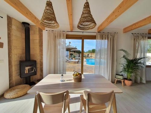 een eetkamer met een tafel en een open haard bij Eco Finca Sa Becadeta in Llucmajor