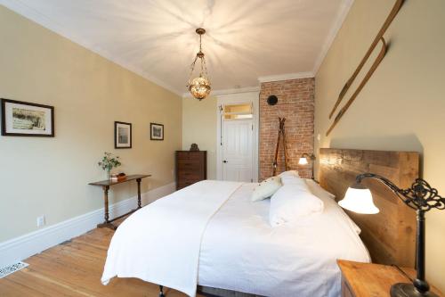 a bedroom with a white bed and a brick wall at The Copeland in Revelstoke