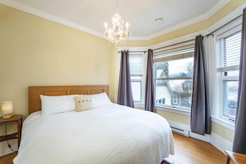 a bedroom with a white bed and a chandelier at The Copeland in Revelstoke