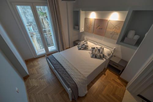a bedroom with a bed and a large window at Kliton Comfort Portaremounta Apartment in Corfu