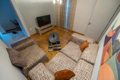 a living room with two couches and a television at Kliton Comfort Portaremounta Apartment in Corfu