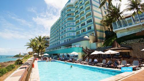 a large hotel with a swimming pool next to the ocean at Vila Galé Salvador in Salvador